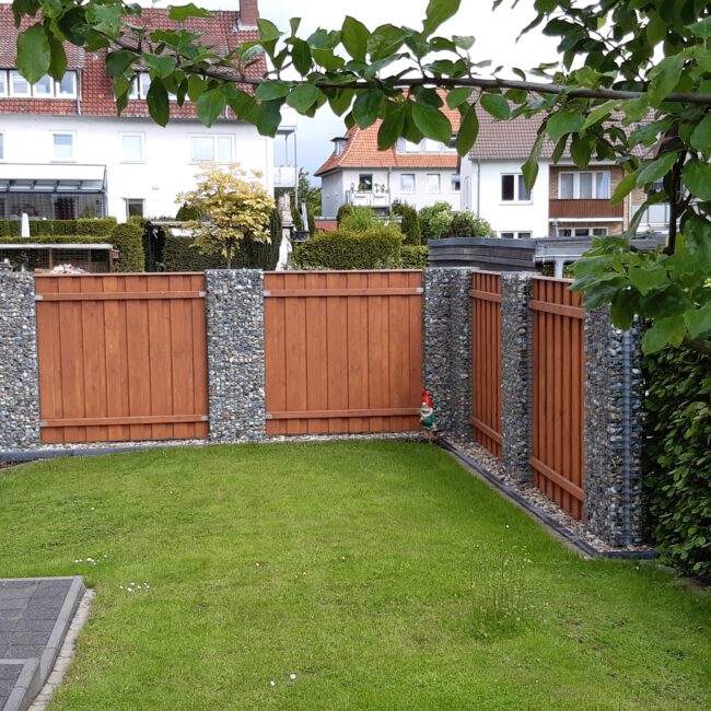 Rot / Braun gestrichener Zaun mit Gabionen Abtrennungen