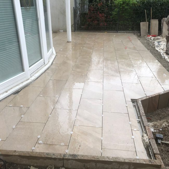 Moderne Terrasse mit langen glänzenden Steinplatte neben Erkerfenster