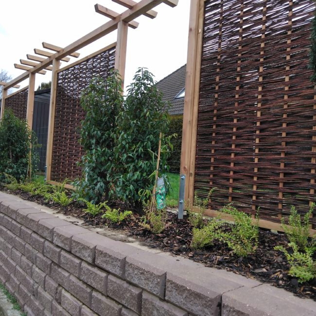 Schöner Sichtschutz mit eingebautem Beet und Hecke auf Mauer