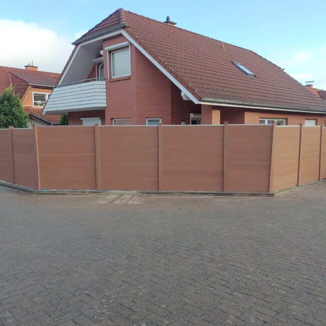 Großes Haus umgeben von einem Holz Sichtschutz