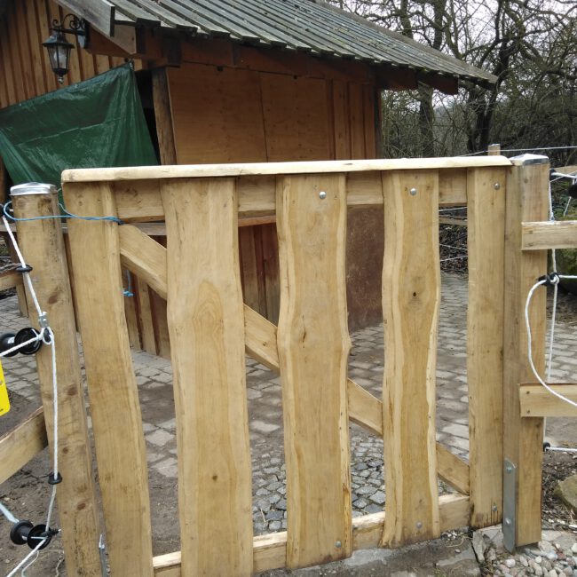 kleine Rohholzzauntür aus geschnittenen Baumstämmen