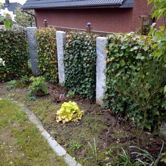 Sichtschutz bestehend aus abwechselnden Palisaden und Hecken hinter einem Beet