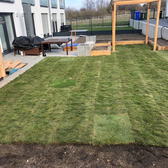 Rasen im Bauprozess neben Terrasse und Schaukel
