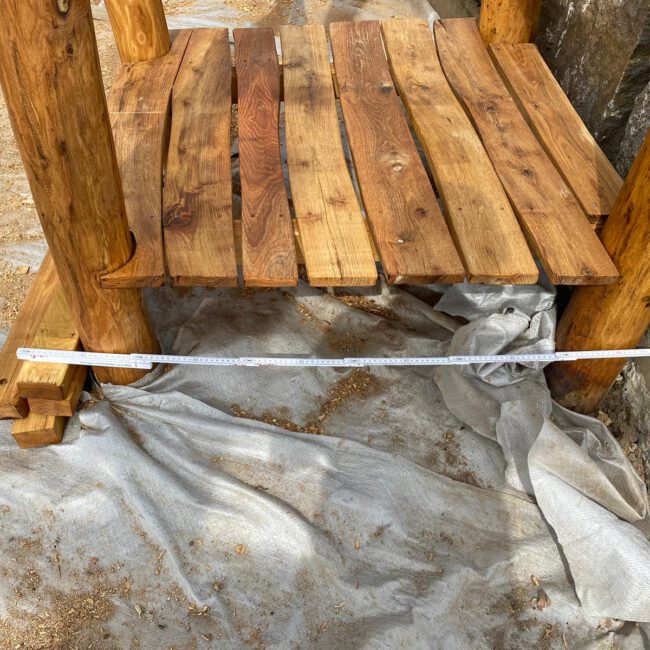 Holztreppe aus abgestreiftem Holz wird beim Bau mit Zollstock gemessen