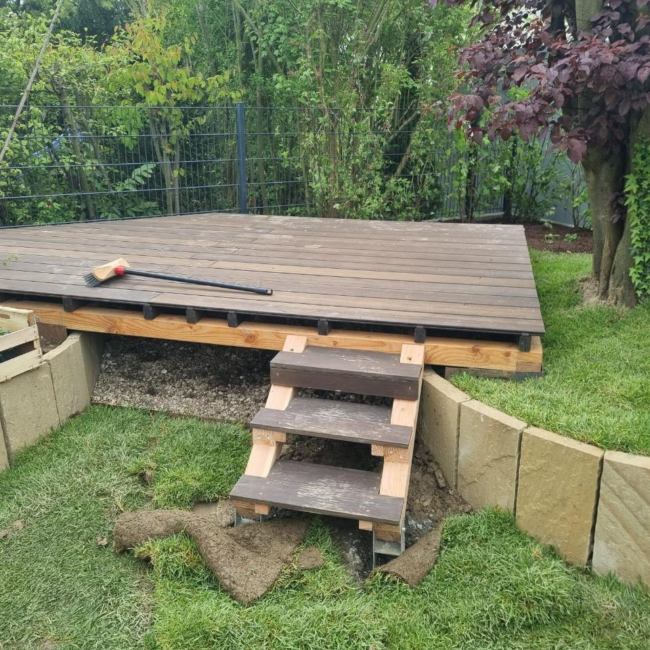 Kleine Holzstufen führen zu Terrasse hoch